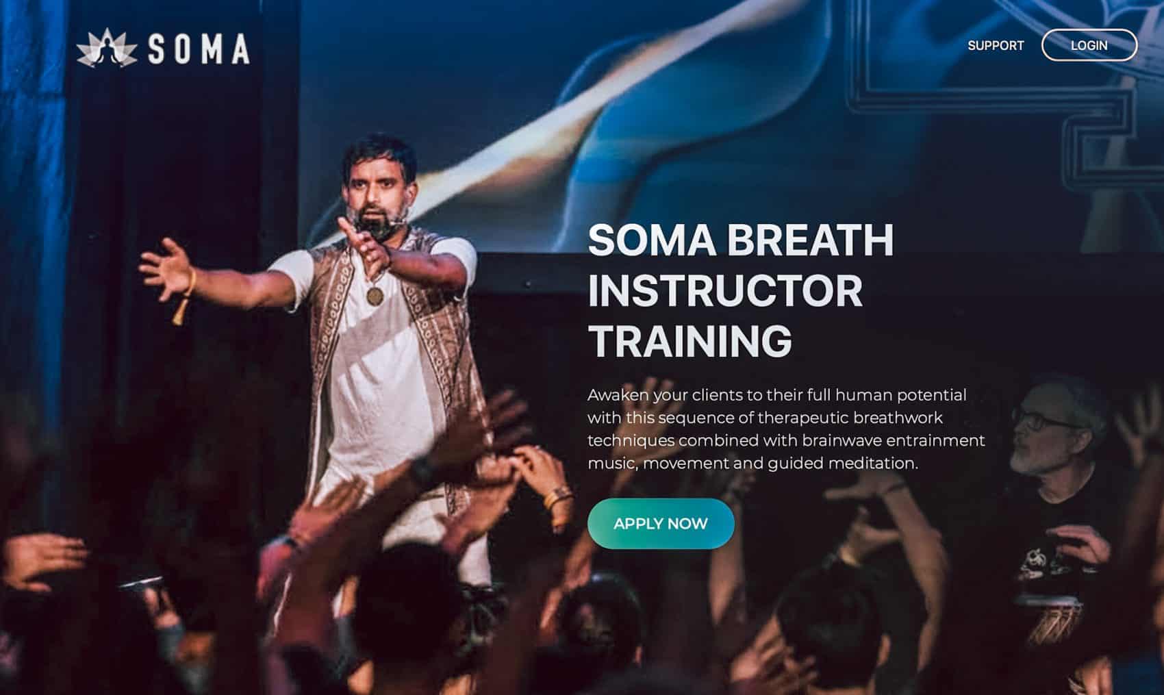 Indian man speaking on stage in public holding arms forward  best YTT Alliance certified  Soma Breath