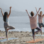 yoga group class by the beach Yoga instructor assisting studentsdoes yoga burn calories? how many calories does yoga burn yoga calories burned hot calculator
